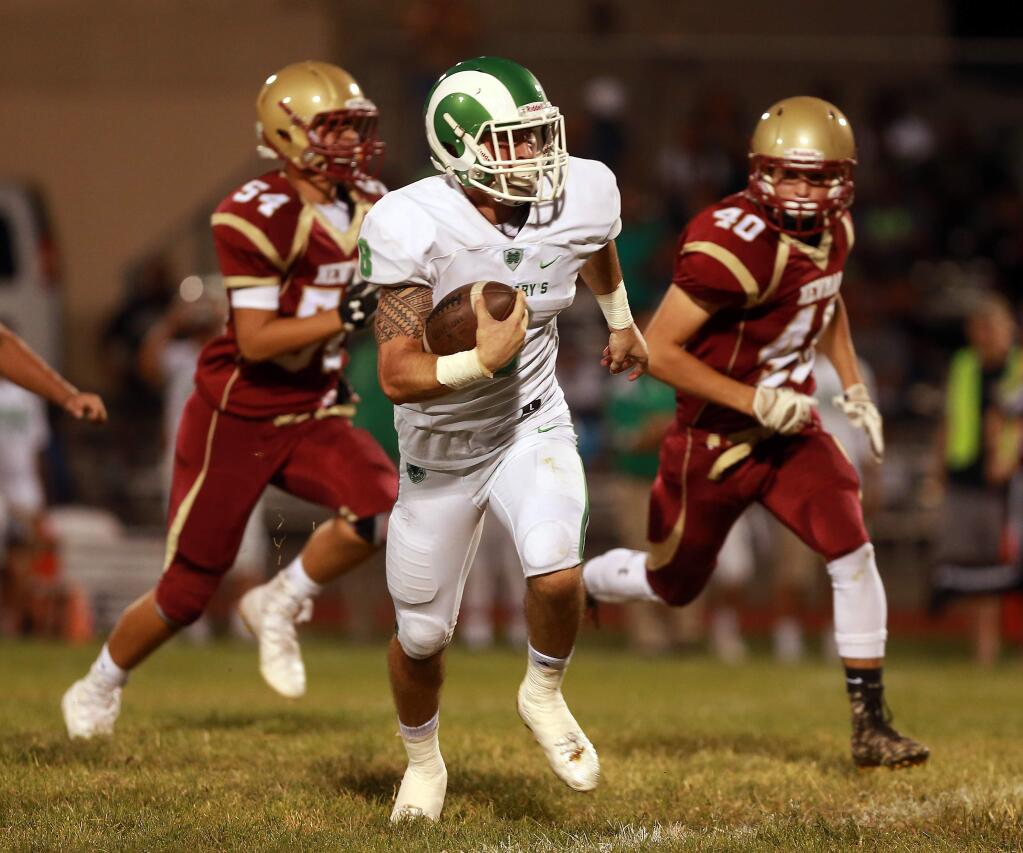 St. Mary's running back Marcus Aponte runs past Cardinal Newman's Noah Steverson, left, and Marco LaFranchi for a 54 yard 1st quarter touchdown on Friday night. (John Burgess/The Press Democrat)