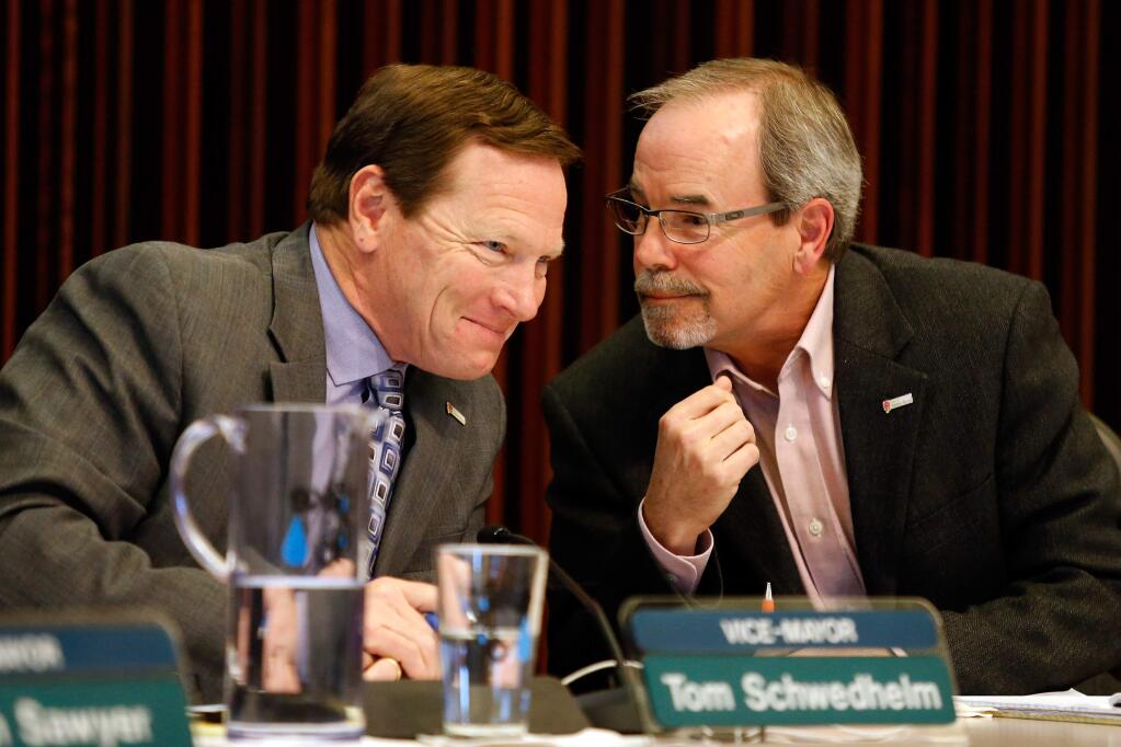 Santa Rosa vice-mayor Tom Schwedhelm, left, and city councilmember Chris Coursey talk with each other during a city council meeting in Santa Rosa, California, on Tuesday, December 6, 2016. (Alvin Jornada / The Press Democrat)