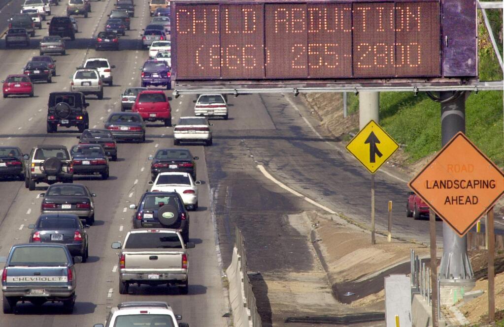 An Amber Alert message is displayed on a Caltrns message board on Interstate 10 in Los Angeles. (NICK UT / Associated Press, 2002)