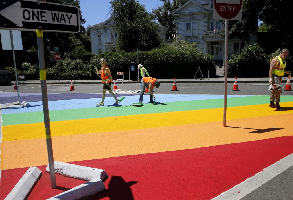 Volunteers paint a 1,200-square-foot rainbow flag in the median at the intersection of Healdsburg Avenue and B Street in Santa Rosa on Thursday, June 28, 2018. (BETH SCHLANKER/ PD)