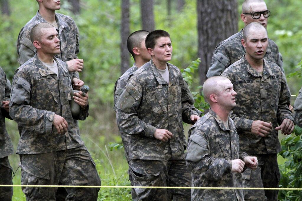 In this photo taken on April 19, 2015, one of the 20 female soldiers, center, who is among the 400 students who qualified to start Ranger School, runs in place in between obstacles on the Darby Queen, one of the toughest obstacle courses in U.S. Army training, at Fort Benning, in Ga. Two women have passed the Armys grueling Ranger test, but tougher and more dangerous jobs could lie ahead, senior officials told The Associated Press. The military services are poised to allow women to serve in most front-line combat jobs, including as special operations forces. (Robin Trimarchi/Ledger-Enquirer via AP) MANDATORY CREDIT