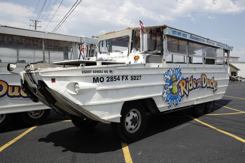 FILE - In this July 20, 2018, file photo, a duck boat sits idle in the parking lot of Ride the Ducks, an amphibious tour operator in Branson, Mo. A lawsuit seeking $100 million in damages was filed Sunday, July 29, against the owners and operators of a duck boat that sank July 19. (AP Photo/Charlie Riedel, File)