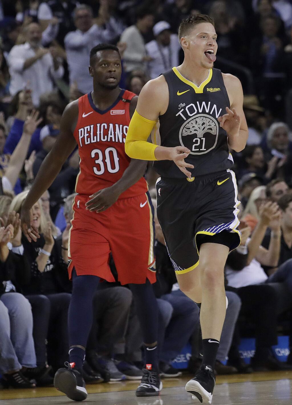 Golden State Warriors forward Jonas Jerebko celebrates after scoring in front of New Orleans Pelicans forward Julius Randle during the first half in Oakland, Wednesday, Oct. 31, 2018. (AP Photo/Jeff Chiu)