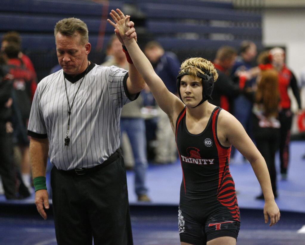 In this Feb. 18, 2017 photo, Euless Trinity's Mack Beggs is announced as the winner of a semifinal match after Beggs pinned Grand Prairie's Kailyn Clay during the finals of the UIL Region 2-6A wrestling tournament at Allen High School in Allen, Texas. Beggs, who is transgender, is transitioning from female to male, won the girls regional championship after a female opponent forfeited the match. (Nathan Hunsinger/The Dallas Morning News via AP)