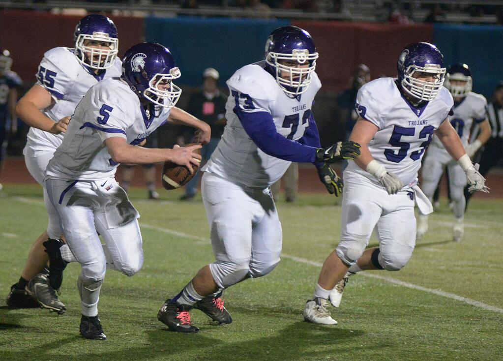 SUMNER FOWLER/FOR THE ARGUS-COURIERPetaluma quarterback Brenden White (5) is escorted into the end zone by Trojan blocker William O'Neill (55), Jore Beccera (73) and Ben Upton (53) on a second-quarter touchdown run.