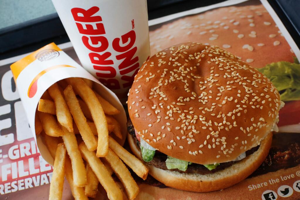 FILE- This Feb. 1, 2018, file photo shows a Burger King Whopper meal combo at a restaurant in the United States. Burger King says it's sorry for offering a lifetime supply of Whoppers to Russian women who get pregnant from World Cup players. (AP Photo/Gene J. Puskar, File)