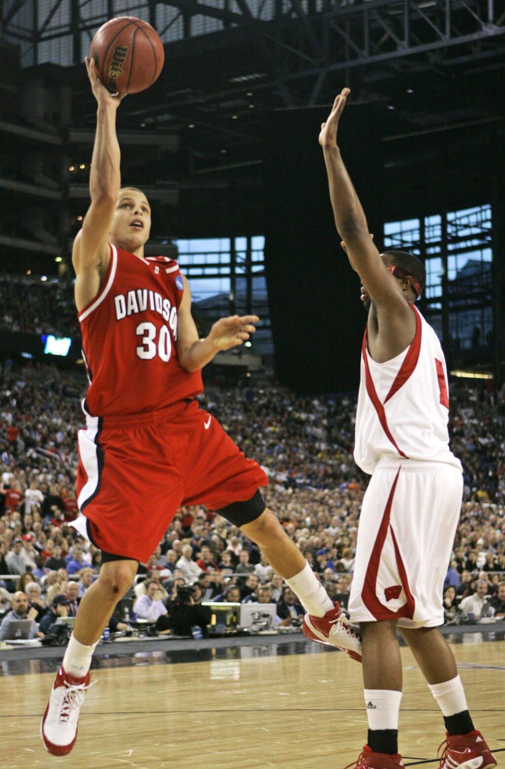 Davidson's Stephen Curry (30) shoots over Wisconsin's Marcus Landry during the first half of an NCAA Midwest Regional semifinal basketball game Friday, March 28, 2008, in Detroit. (AP Photo/Carlos Osorio)
