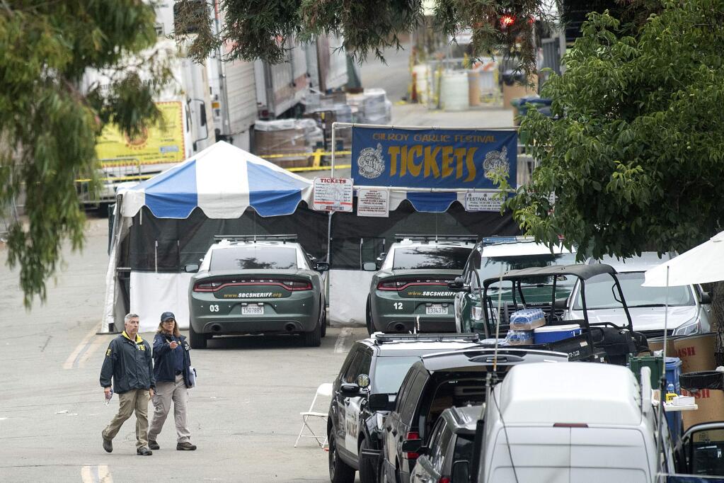 FILE - In this July 29, 2019 file photo FBI personnel pass a ticket booth at the Gilroy Garlic Festival in Calif., the morning after a gunman killed multiple people and wounded over a dozen others. A law enforcement official identified the gunman as Santino William Legan. Legan killed himself, according to a finding by the Santa Clara County coroner's office that contradicts earlier police accounts that officers fired the fatal shot. (AP Photo/Noah Berger, File)