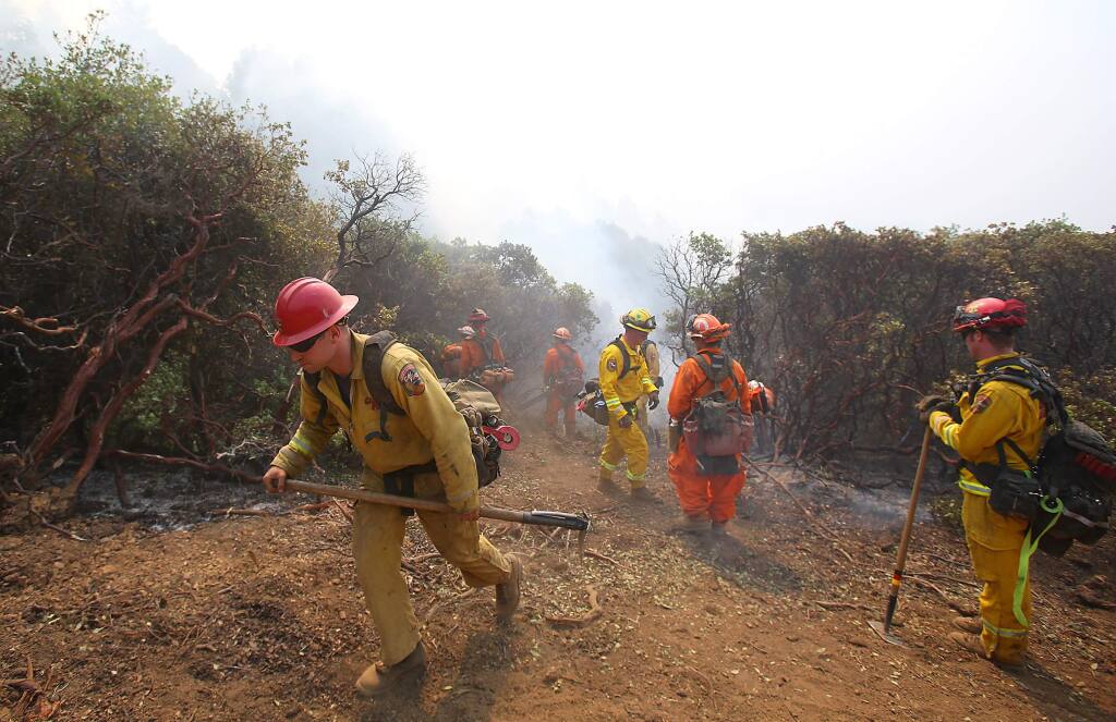 The Toulomne-Calaveras Cal Fire Unit and an inmate crew prepare to set a blackline, from the holding line to the oncoming fire, in order to create a buffer at the northeast corner of the Lodge Complex Fire, north of Laytonville on Monday, Aug. 11, 2014. (Christopher Chung / The Press Democrat)