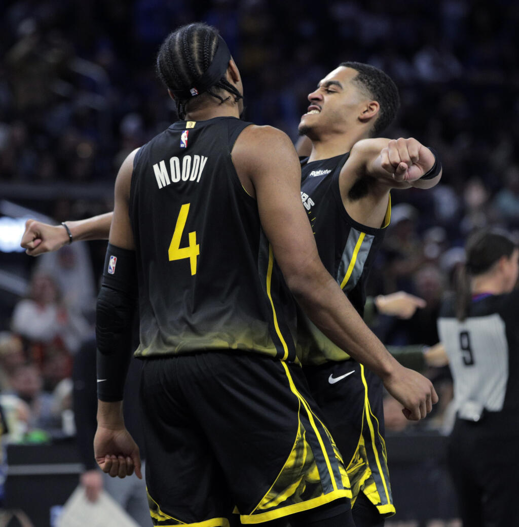 Golden State Warriors' Jordan Poole (3) chest bumps teammate Moses Moody (4) in the second half of an NBA basketball game against the Memphis Grizzlies at Chase Center in San Francisco, Sunday, Dec. 25, 2022. (Carlos Avila Gonzalez/San Francisco Chronicle via AP)