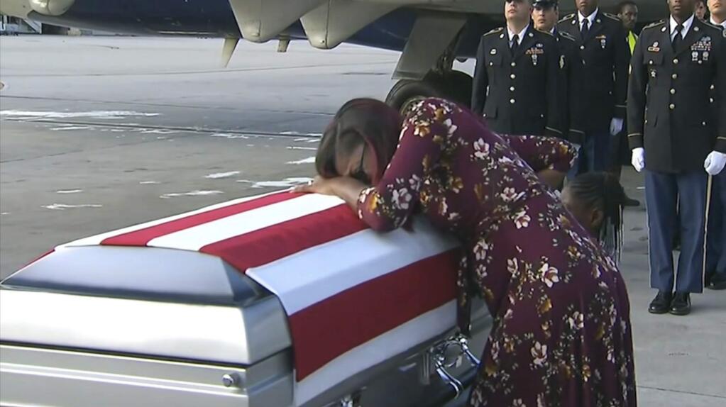 ADDS TRUMP'S RESPONSE TO REP. WILSON - In this Tuesday, Oct. 17, 2017, frame from video, Myeshia Johnson cries over the casket of her husband, Sgt. La David Johnson, who was killed in an ambush in Niger, upon his body's arrival in Miami. President Donald Trump told the widow that her husband 'knew what he signed up for,' according to Rep. Frederica Wilson, who said she heard part of the conversation on speakerphone. In a Wednesday morning tweet, Trump said Wilson's description of the call was 'fabricated.' (WPLG via AP)