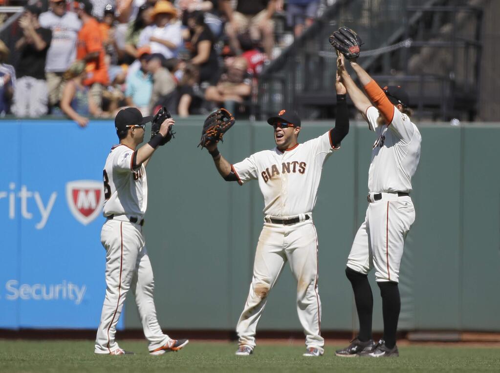 From left, San Francisco Giants outfielders Nori Aoki, Gregor Blanco, and Hunter Pence celebrate at the end of their baseball game against the Milwaukee Brewers, Wednesday, July 29, 2015, in San Francisco. San Francisco won the game 5-0. (AP Photo/Eric Risberg)