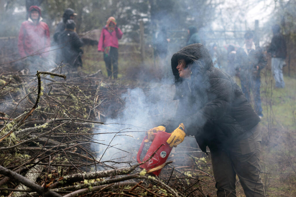 Adrienne Leddy, of the Chamorro indigenous people, practices prescribed burn techniques during a "Rekindling Culture and Fire" at the Cultural Conservancy's Heron Shadow Farm in Sebastopol on Sunday, Feb. 26, 2023. (Beth Schlanker/The Press Democrat)