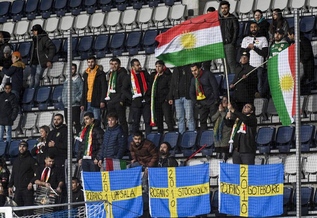 In this photo taken on Saturday Oct. 20, 2018, Dalkurd's soccer fans wave Kurdish flags, top, and Swedish flags below, in the stands during the Swedish League soccer match between Dalkurd and Orebro at Gavlevallen soccer field in Gavle, Sweden. The 14-year journey of the soccer team known as Dalkurd began as a social project to get misbehaving kids off the street in a rural town in central Sweden. Now, it has grown into a top-flight squad that has given the Kurdish minority - scattered and ravaged by war - something to cherish as its own. (Pontus Lundahl/TT via AP)