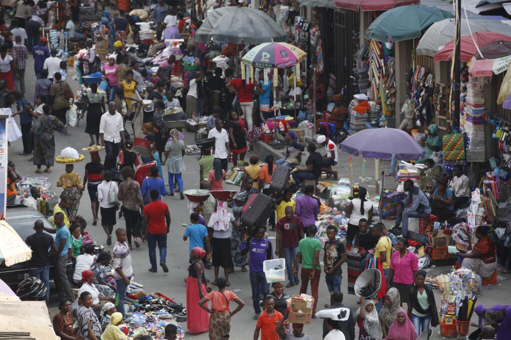 Pedestrians shop for wares in a Market in Lagos, Nigeria, one of the West African countries where authorities are battling to contain the spread of Ebola. (SUNDAY ALAMBA / Associated Press)