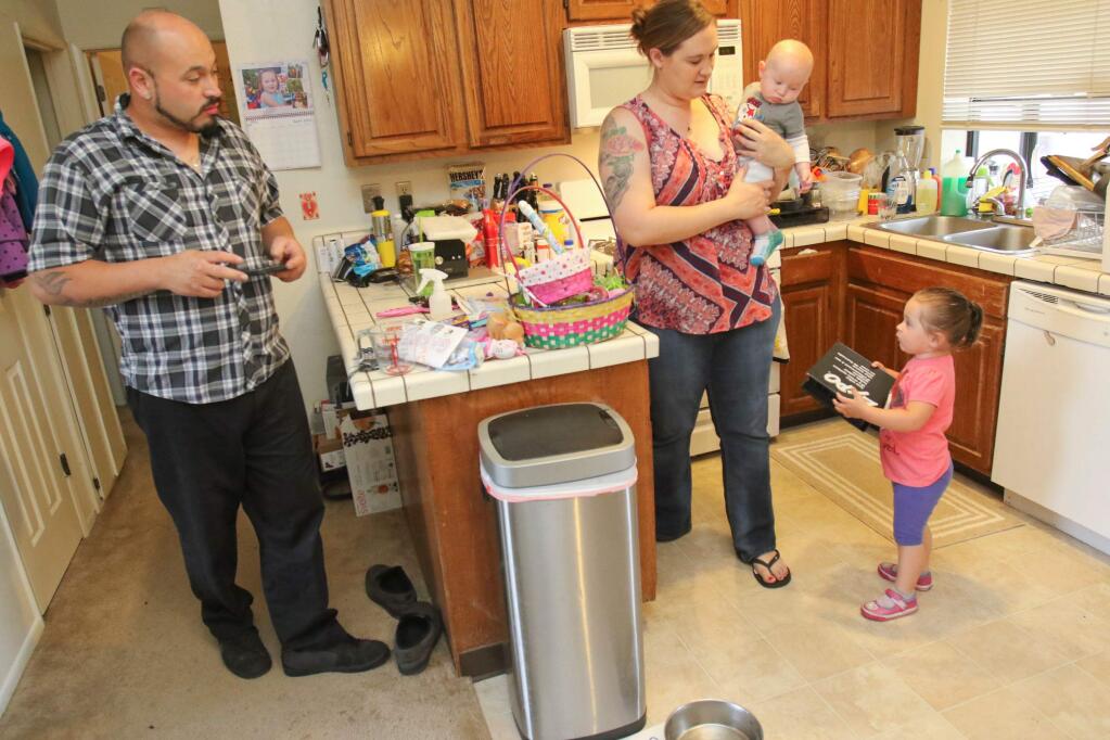 The Gutierrez family, Jason, Cathy Killinger, and their children Gabriela 'Gabby', 2 years, and Julian, 4 months, in their Petaluma home that they are in the process of being evicted from on Monday, April 6, 2015. (SCOTT MANCHESTER/ARGUS-COURIER STAFF)