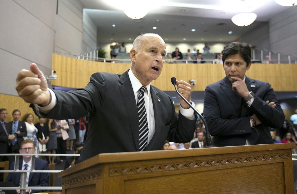 California Gov. Jerry Brown, left, joined by Senate President Pro Tem Kevin de Leon, D-Los Angeles, urges members of the Senate Environmental Quality Committee to approve a pair of climate change bills, Thursday, July 13, 2017, in Sacramento, Calif. The committee advanced the the bills, AB 398, that would extend the state's cap and trade program. and AB617. that is intended to improve air quality around oil refineries. (AP Photo/Rich Pedroncelli)