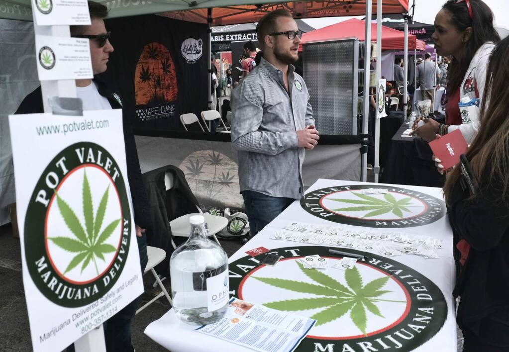 FILE - This March 31, 2018 photo shows a booth advertising a delivery service for cannabis at the Four Twenty Games in Santa Monica, Calif. Three California agencies released proposed regulations Friday, Dec. 7, 2018, for the state's marijuana industry including deliveries that will become permanent next month after state lawyers finish their review of them. Law enforcement groups and cities with marijuana bans unsuccessfully fought against it. (AP Photo/Richard Vogel, File)
