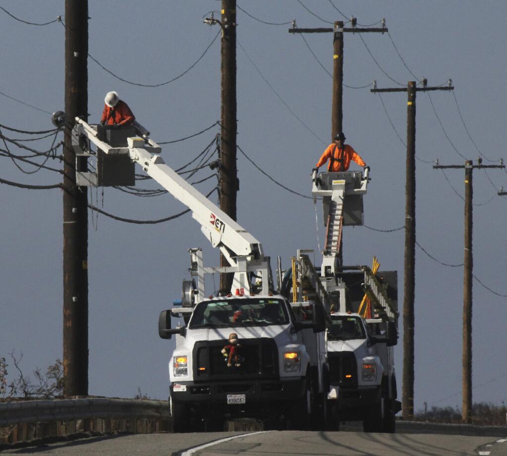 FILE - In this Sunday, Nov. 25, 2018 file photo, utility crews repair overhead lines along the Pacific Coast Highway just west of Malibu, Calif., where the Woolsey Fire burned down from the Santa Monica Mountains to the water's edge at Leo Carrillo State Beach. To prevent wildfires, Pacific Gas & Electric Co. should re-inspect its entire electric grid and cut off power during certain wind conditions regardless of the inconvenience to customers or loss of profit, a U.S. judge proposed Wednesday, Jan. 9, 2019. (AP Photo/John Antczak, File)