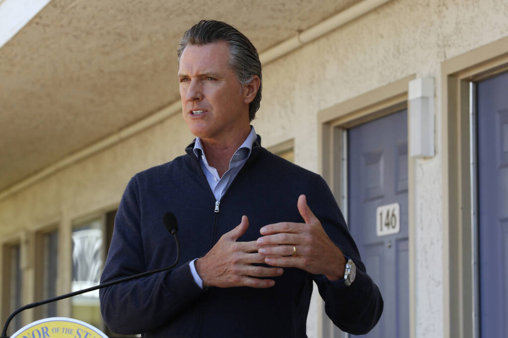 Gov. Gavin Newsom gives an update on the state’s initiative to provide housing for homeless Californians to help stem the coronavirus, during a visit to a Motel 6 participating in the program in Pittsburg, Calif., Tuesday, June 30, 2020.  Newsom announced that more than 15,000 rooms have been acquired and more than 14,000 people have been given places to stay statewide under the Project Room key program started in April. The governor also said he plans to announce on Wednesday plans to “toggle back” the states stay-at-home order. (AP Photo/Rich Pedroncelli, Pool)