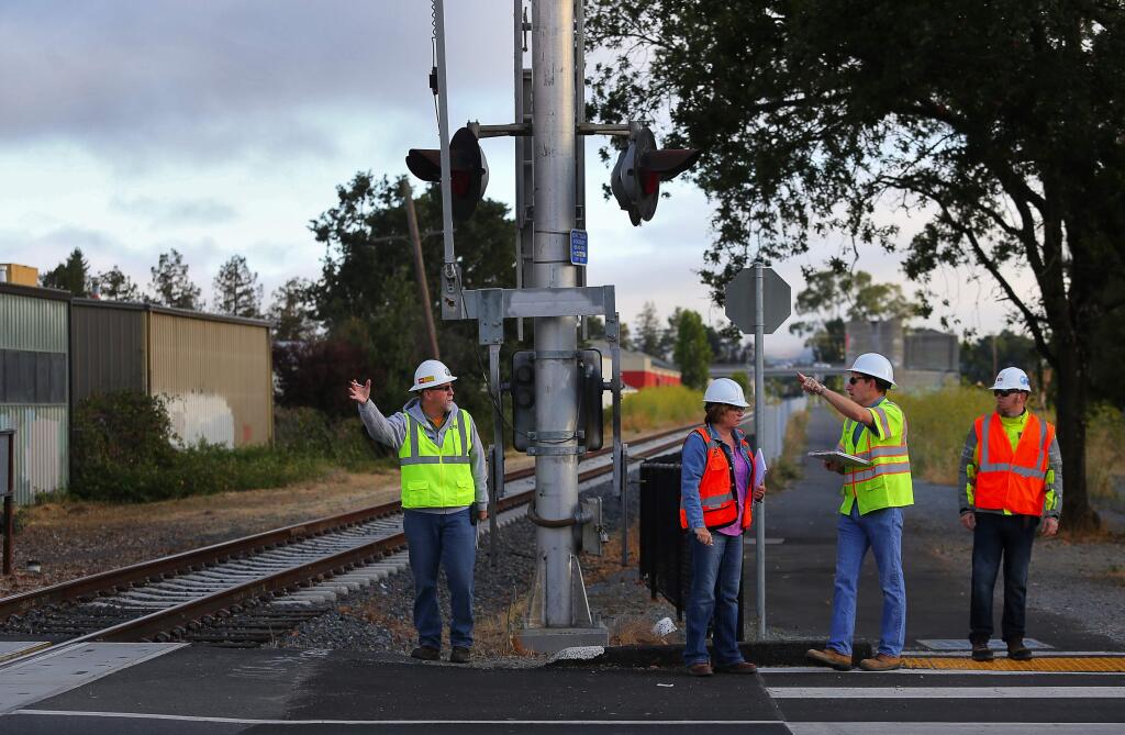 California Public Utilities Commission Safety and Enforcement Division utitilites engineer Dave Stewart, left, LeeAnn Dickson, a regional grade crossing trespassing prevention manager for the Department of Transportation Federal Railroad Administration, Rob Sprinkle, deputy director of traffic for Santa Rosa, and Aaron Parkes, systems consultant with LTK Engineering Services, look over the rail crossing at Barham Avenue, in Santa Rosa, to determine if the area has the necessary equipment to be eligible for a quiet zone designation, on Friday, August 12, 2016. (Christopher Chung/ The Press Democrat)