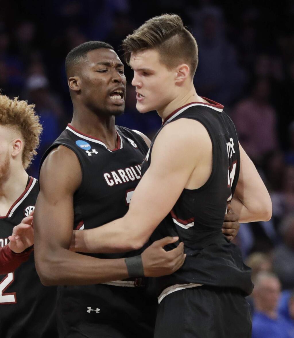 South Carolina forward Sedee Keita, left, congratulates forward Maik Kotsar (21) after Kotsar scored against Florida during the second half of the East Regional championship game of the NCAA men's college basketball tournament, Sunday, March 26, 2017, in New York. (AP Photo/Julio Cortez)