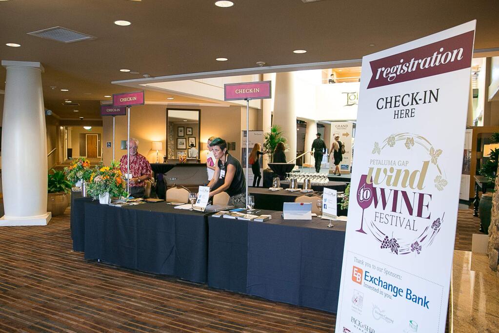 The check-in table gets ready to greet guests at the Petaluma Gap's inaugural WIND to WINE Festival at the Sheraton Petaluma on Saturday, August 8, 2015. (RACHEL SIMPSON/FOR THE ARGUS-COURIER)