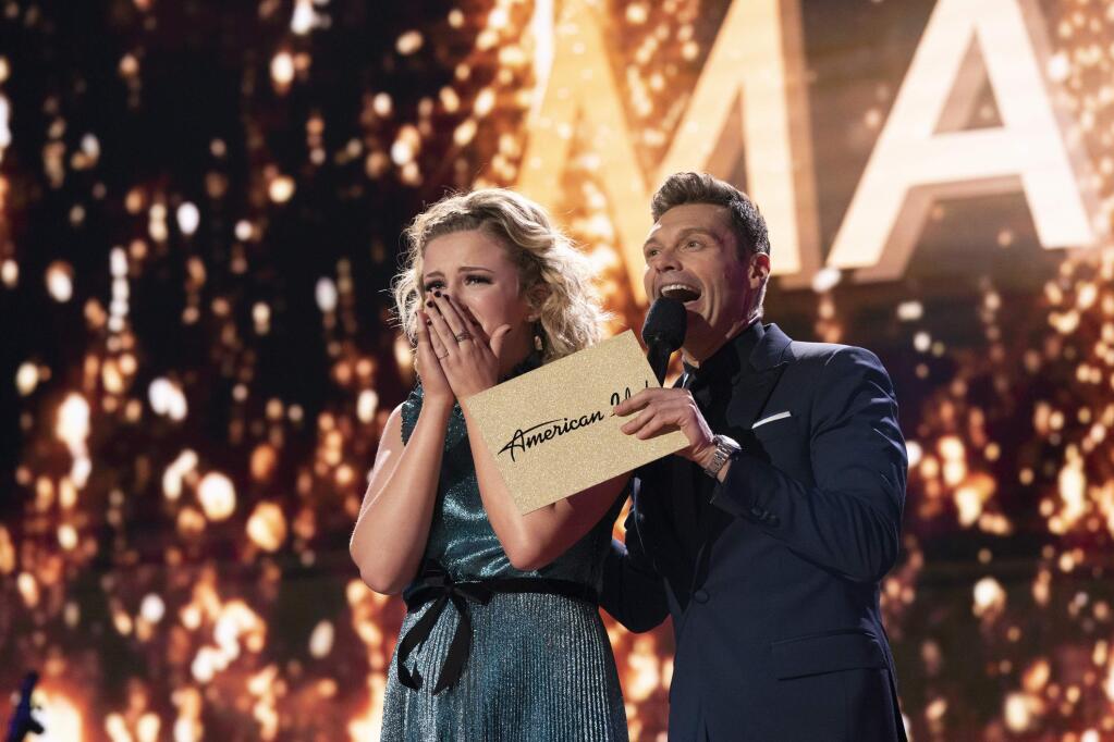 In this May 21, 2018 photo provided by ABC, Maddie Poppe, left, reacts with Ryan Seacrest after being announced the winner of “American Idol” in Los Angeles. The singer-songwriter bested Caleb Lee Hutchinson and Gabby Barrett in the two-hour finale on ABC. (Mitch Haaseth/ABC via AP)