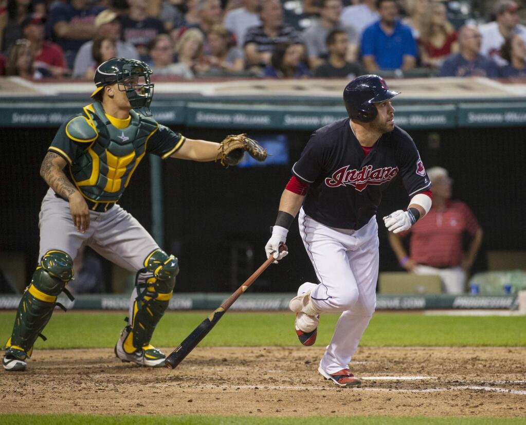 Cleveland Indians' Jason Kipnis heads to first base with a double, next to Oakland Athletics catcher Bruce Maxwell during the fourth inning of a baseball game in Cleveland, Saturday, July 30, 2016. (AP Photo/Phil Long)