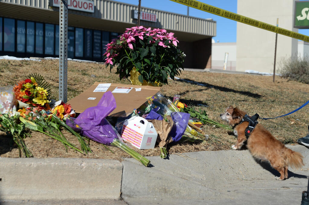 13-year-old dog, Howie Travis, sniffs flowers placed near a gay nightclub in Colorado Springs, Colo., Sunday, Nov. 20, 2022, where a shooting occurred late Saturday night. Police say a 22-year-old gunman opened fire at the gay nightclub, Club Q, killing several people and leaving multiple people injured before he was subdued by “heroic” patrons. (Geneva Heffernan / Associated Press)