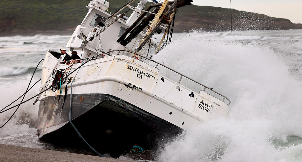Personnel from a salvage crew wait to offload equipment from the Aleutian Storm, Friday, Feb. 16, 2024.  After offloading a pump and fuel hoses, the seas became to rough to continue working on the beached vessel at south Salmon Creek State Beach, north of Bodega Bay.  (Kent Porter / The Press Democrat)