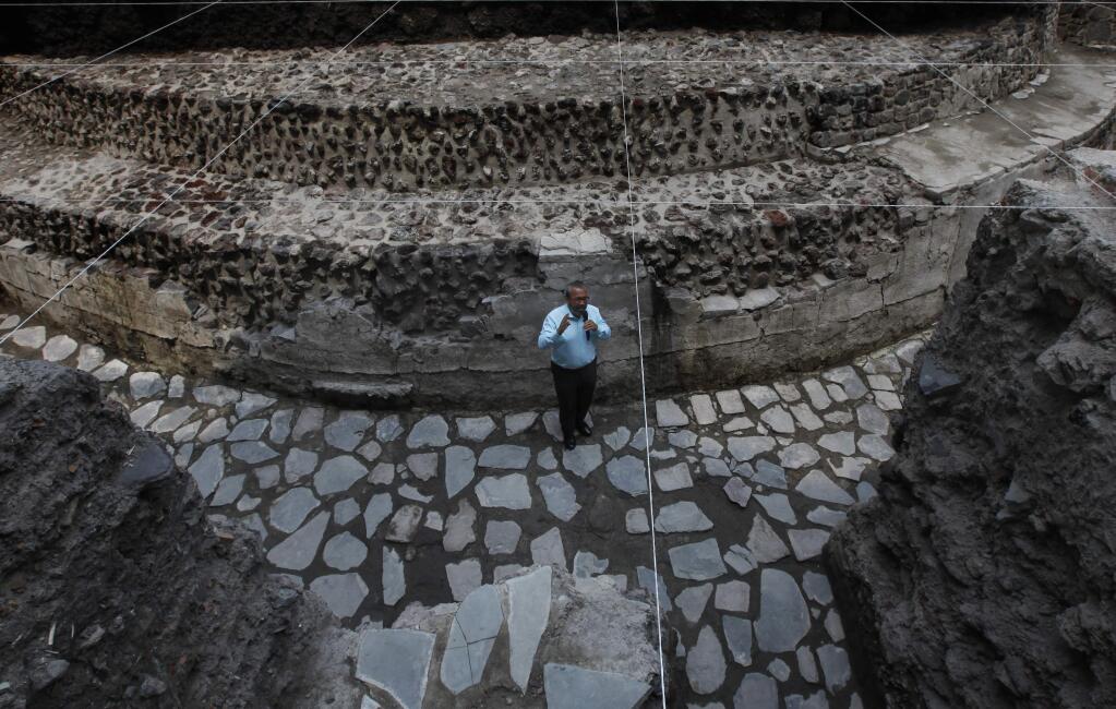 Archaeologist Raul Barrera, from the National Institute of Anthropology and History, talks to the press as he stands in a temple to the Aztec wind god Ehecatl discovered on the property of a hotel in Mexico City, Wednesday, June 7, 2017. Plans to expand the hotel have been put on hold after archaeologists unearthed a 1400's temple and a ceremonial ball court under the property. (AP Photo/Marco Ugarte)