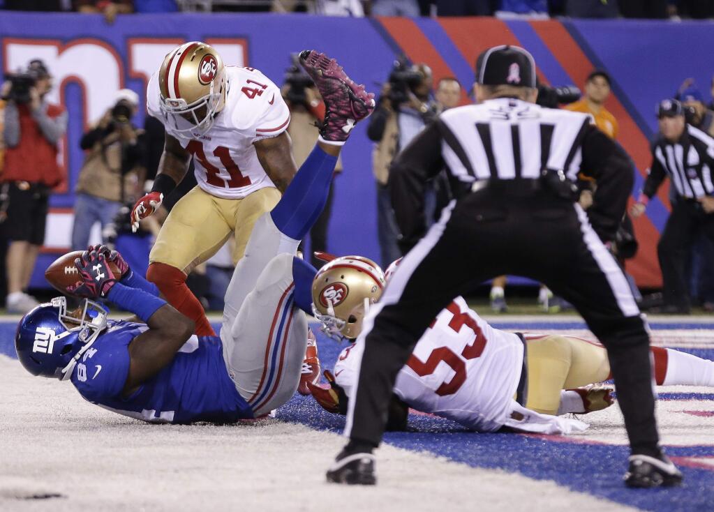 New York Giants tight end Larry Donnell (84) comes down with a catch for the game-winning touchdown as San Francisco 49ers strong safety Antoine Bethea (41) and inside linebacker NaVorro Bowman (53) defend during the fourth quarter of an NFL football game, Sunday, Oct. 11, 2015, in East Rutherford, N.J. The Giants won 30-27. (AP Photo/Seth Wenig)