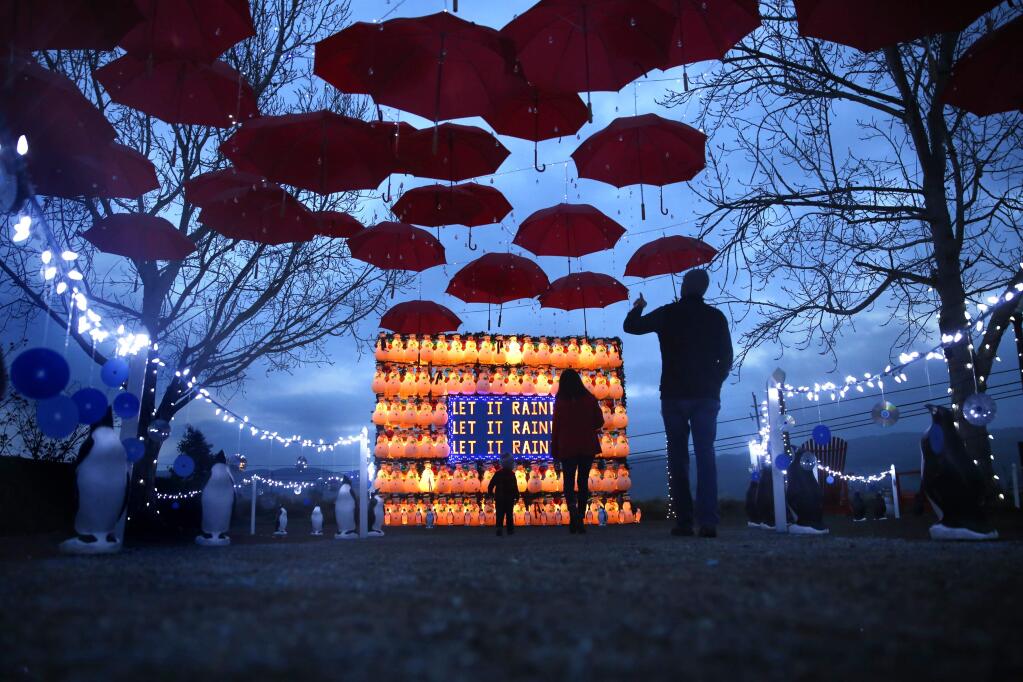 Dylan McCrum, his wife, Katie, and son Elliot, 19-months old, visit the holiday display of lighted snowmen and red umbrellas at CornerStone Sonoma in 2015 . (BETH SCHLANKER/ The Press Democrat)
