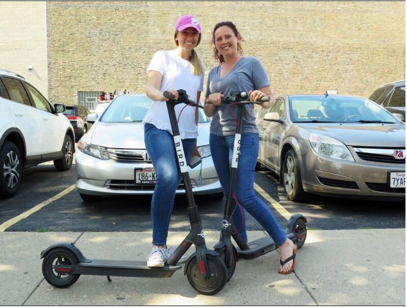 Kirby Bridges, left, and Megan Garlington pose with the Bird scooters they were taking for an afternoon ride in Milwaukee, Wisconsin. Bird scooters may soon be available in Windsor. During Wednesday night’s upcoming council session, town leaders will discuss a pilot program to bring the electric scooters to the area possibly during late spring or early summer. (Ivan Moreno / Associated Press, 2018)