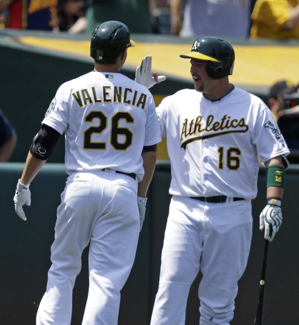 FILE - In this May 28, 2016 file photo Oakland Athletics' Danny Valencia (26) is congratulated by Billy Butler (16) after hitting a home run off Detroit Tigers' Matt Boyd in the fourth inning of a baseball game in Oakland, Calif. Butler and Valencia both were fined by the A's on Monday, Aug. 22, 2016, after a Friday fight in Chicago between the two raised questions as to whether the two men could peacefully coexist in the Oakland clubhouse. 'He's my teammate,' Valencia said when asked about his relationship with Butler. 'I have respect for him I think he has respect for me.' (AP Photo/Ben Margot)