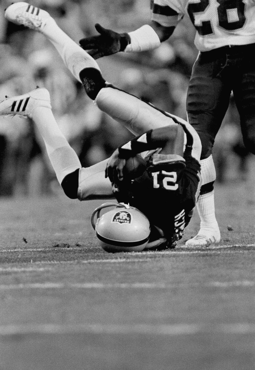 The Los Angeles Raiders' Cliff Branch tumbles to the ground after catching a long pass from quarterback Jim Plunkett during second-quarter action in Super Bowl XVIII against the Washington Redskins in Tampa, Sunday, Jan. 22, 1984. (AP Photo)