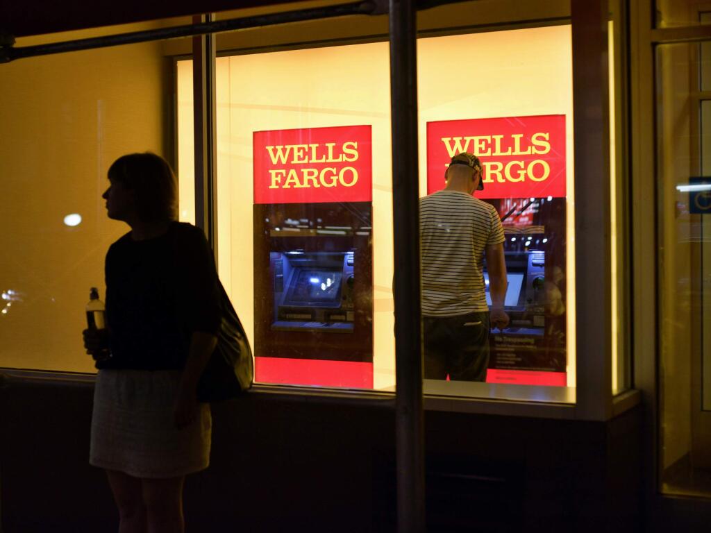 FILE - In this Sept. 21, 2016, file photo, a customer uses a Wells Fargo bank ATM in New York. (AP Photo/Patrick Sison, File)