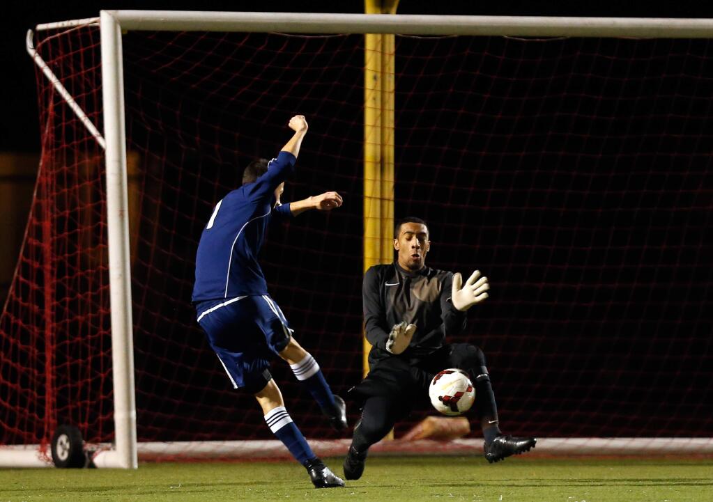 Montgomery goalkeeper Jordan Page, right, blocks a shot on goal by Rancho Cotate's Jesus Contreras (11) during the first half of a boys varsity soccer match Friday, January 8, 2016. (Alvin Jornada / The Press Democrat)