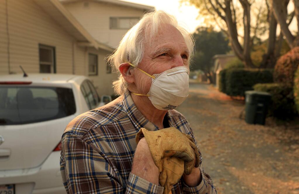 Steve Smith takes a rest from raking leaves near his home in Santa Rosa, as he wears a mask because of the Camp fire in Butte County, Thursday, Nov. 8, 2018. Sonoma County health officials said Friday morning local air quality reached “very unhealthy” levels. (Kent Porter / The Press Democrat) 2018