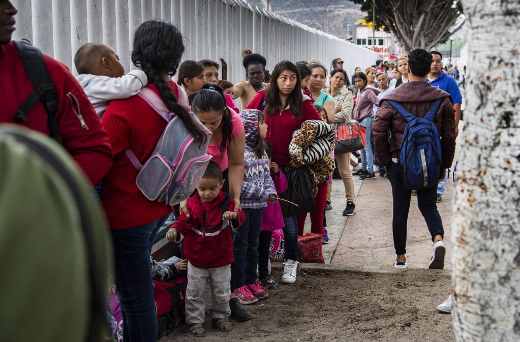 Asylum-seeking immigrants line up at a border fence in Tijuana, Mexico on June 20, 2018. (Gina Ferazzi/Los Angeles Times/TNS)