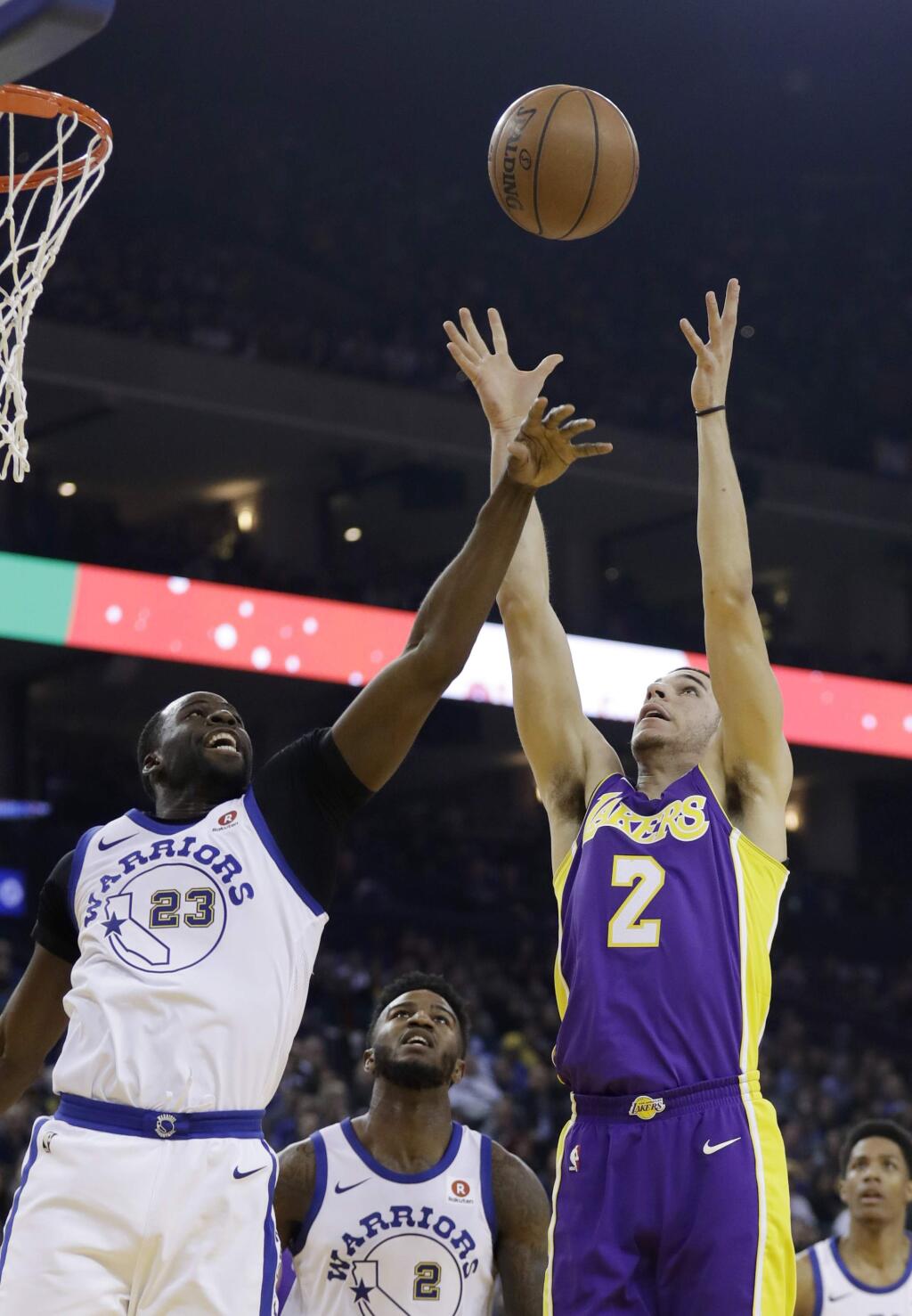Golden State Warriors forward Draymond Green (23) and Los Angeles Lakers guard Lonzo Ball (2) vie for a rebound during the first half of an NBA basketball game Friday, Dec. 22, 2017, in Oakland, Calif. (AP Photo/Marcio Jose Sanchez)