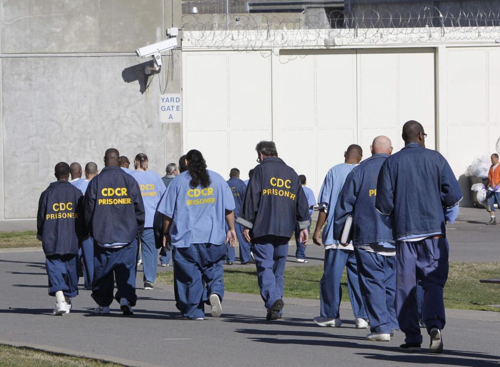 FILE - In this Feb. 26, 2013, file photo, inmates walk through the exercise yard at California State Prison Sacramento, near Folsom, Calif. (AP Photo/Rich Pedroncelli, File)