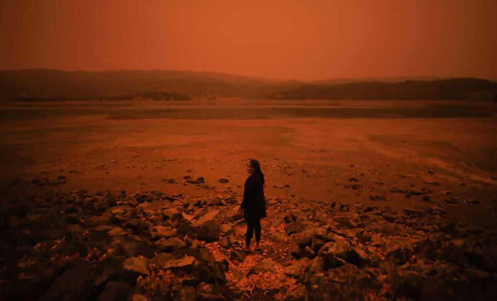 Drought-plagued Lake Mendocino, coupled with dense smoke from the August Complex and other Northern California wildfires, gives reason for Fernanda Chavez of Ukiah to pause at the Mars-like surroundings, Wednesday, Sept. 9, 2020  (Kent Porter / The Press Democrat) 2020