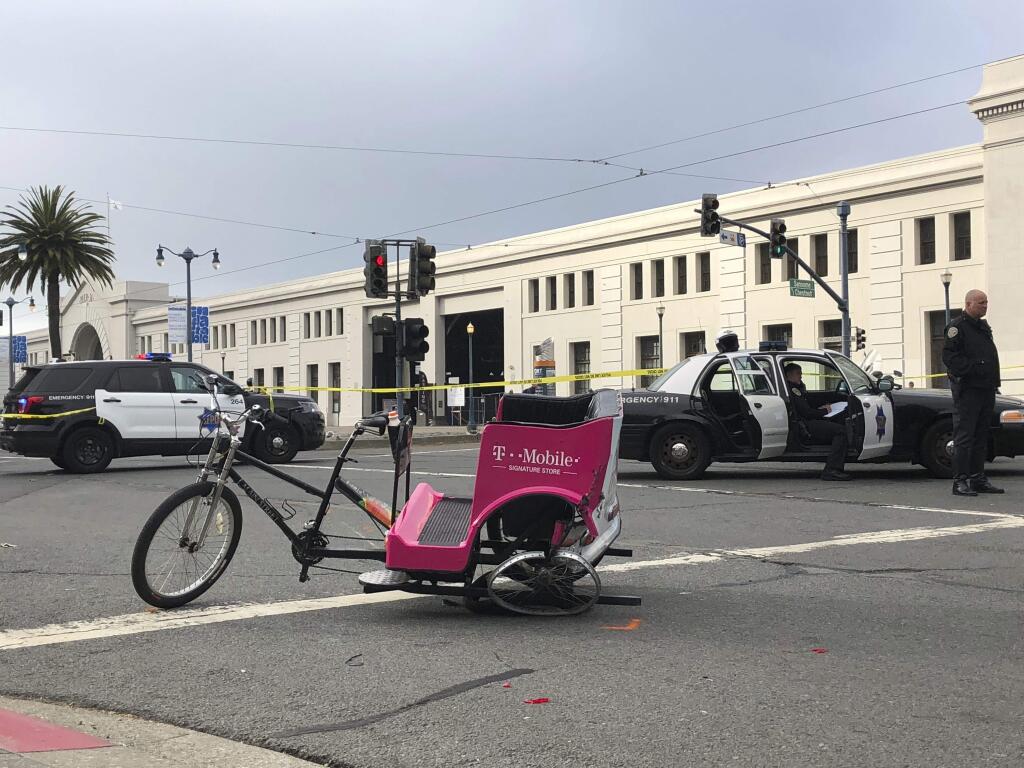 A crashed pedicab is seen on the street in San Francisco on Wednesday, June 27, 2018, after authorities said a hit-and-run driver crashed into it, injuring several people. The crash happened along the embarcadero, a long, wide stretch of walkway that links restaurants and tourist attractions and is typically crowded with joggers, cyclists, walkers and tourists. (AP Photo/Juliet Williams)