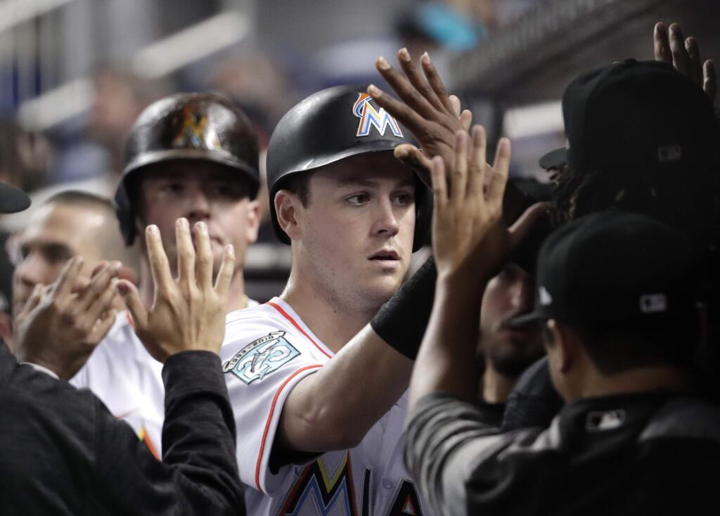 Miami Marlins' Brian Anderson is congratulated in the dugout after scoring on a double by JT Riddle during the third inning of a baseball game against the San Francisco Giants, Tuesday, June 12, 2018, in Miami. (AP Photo/Lynne Sladky)