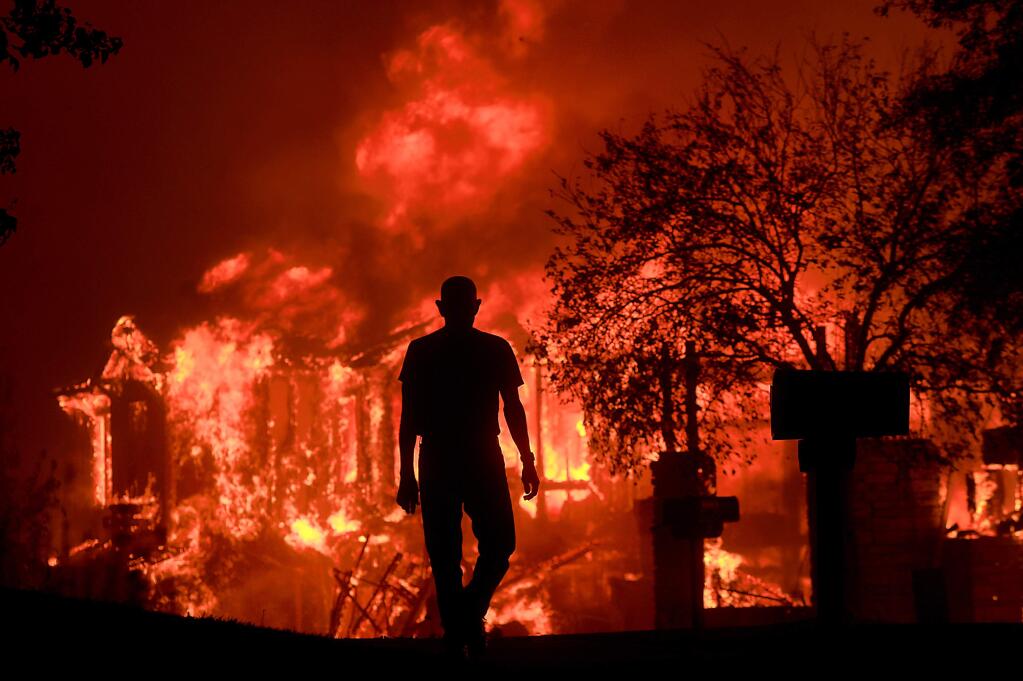 Bill Stites watches his neighborhood burn in the hillside neighborhood of Fountaingrove early on Oct. 9, 2017. Skeleton crews of firefighters had mostly given up on saving homes that sat in the path of high winds. A fire engineer told us, “It was like Armageddon, something I've never seen before and hope to never see again.” Oct. 9, 2017. (KENT PORTER / PRESS DEMOCRAT)