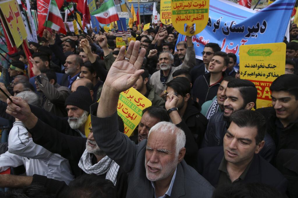 Demonstrators chant slogans during an annual rally in front of the former U.S. Embassy in Tehran, Iran, on Sunday, Nov. 4, 2018, to mark the 39th anniversary of the seizure of the embassy by militant Iranian students. Thousands of Iranians rallied in Tehran on Sunday to mark the anniversary as Washington restored all sanctions lifted under the nuclear deal. (AP Photo/Vahid Salemi)