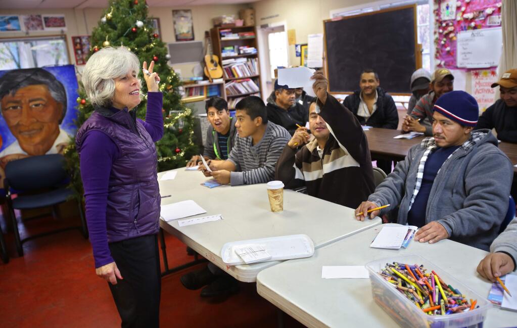 Volunteer Jo Anne Cohn, left, teaches a driver's license prep course at the Graton Day Labor Center on Wednesday, December 17, 2014. (Christopher Chung/ The Press Democrat)