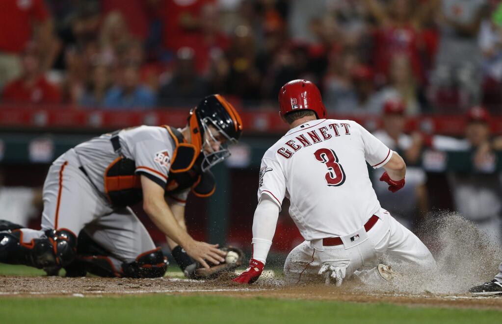 The Cincinnati Reds' Scooter Gennett scores on a sacrifice fly by Phillip Ervin as San Francisco Giants catcher Buster Posey, left, takes the throw during the fifth inning Saturday, Aug. 18, 2018, in Cincinnati. (AP Photo/Gary Landers)
